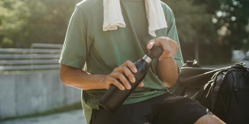 A person holding a water bottle during a break.